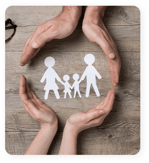 A paper cut out of a family with hands around them.